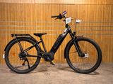 un vélo électrique noir garé devant un mur en bois