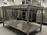 a large stainless steel table in the middle of a kitchen