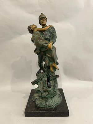 bronze statue of a man holding a child on a rock