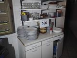 une cuisine avec beaucoup de vaisselle sur le comptoir