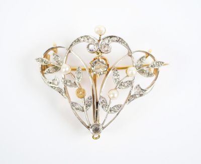 a close up of a brooch with pearls and diamonds