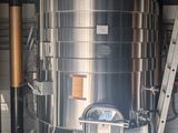 a large stainless steel tank with a ladder next to it