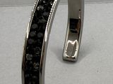 bracelet en argent orné de pierres noires sur un fond blanc
