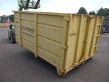 a large yellow dumpster sitting in a parking lot