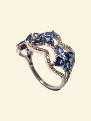 a close up of a diamond and sapphire ring on a white background