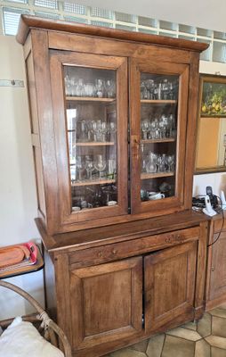 a wooden china cabinet with glass doors in a room