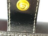 a close up of a black purse with a yellow handle