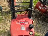 une tondeuse à gazon rouge posée par terre