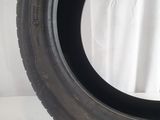 tire of a car on a white surface with a white curtain in the background