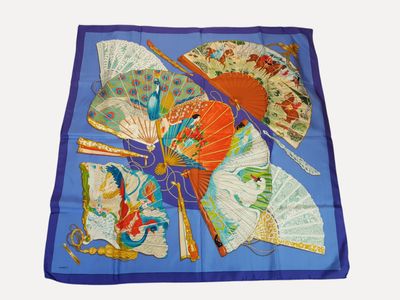 a blue scarf with a picture of a fan and a pair of scissors