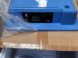 une boîte bleue avec un couvercle bleu posée sur une boîte en carton