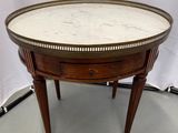 une table ronde avec un plateau en marbre et des pieds en bois