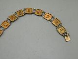 a close up of a gold bracelet with letters on it