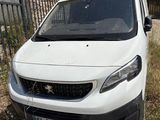 une petite camionnette blanche garée devant une clôture