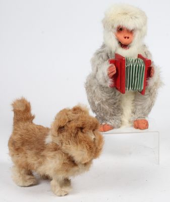 un petit chien debout à côté d'une peluche