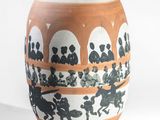 a white vase with black and orange designs on it