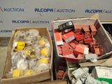 two boxes of assorted electrical components sitting on the ground