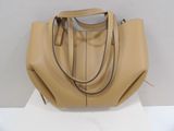 a tan leather handbag sitting on top of a white table