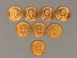 six gold coins are arranged in the shape of a heart