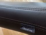 a close up of a black leather seat with a name tag on it