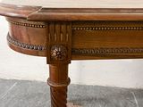 a wooden table with a marble top on a stone floor
