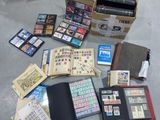 une boîte remplie de timbres et un livre par terre