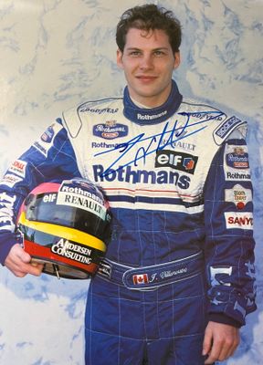 a man that is holding a helmet and posing for a picture