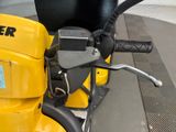 a close up of a yellow moped parked on the side of the street