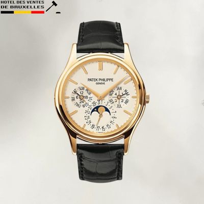 La montre est en or, avec un cadran blanc et un bracelet en cuir noir.