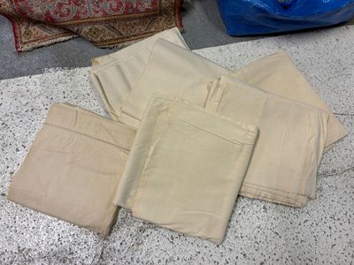 une pile de pantalons beiges posée par terre