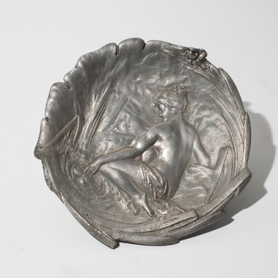 an image of a silver plate with a woman on it