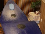 une planche de surf bleue posée dans une salle de bains, à côté des toilettes