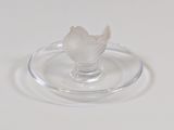 une plaque de verre sur laquelle est représentée une fleur, posée sur un fond blanc
