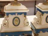 two blue and white vases on a table with a clock in the background