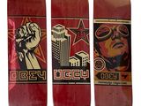 three red skateboards with a picture of a man holding a fist