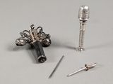 un petit objet en argent et un autre petit objet en argent posés sur une table