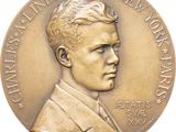 une image représentant une médaille de bronze sur laquelle figure le visage d'un homme