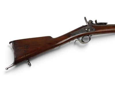 un vieux fusil avec un canon en bois et des garnitures métalliques