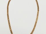 un collier à chaîne en or sur fond blanc