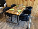 une table en bois avec quatre chaises et un verre à vin posé dessus