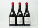 trois bouteilles de vin rouge sont alignées sur une surface blanche