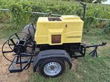 a yellow and black machine sitting on top of a grass covered field