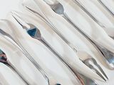 a lot of forks and spoons sitting on a table