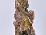 bronze statue of a woman sitting on a bench with a basket