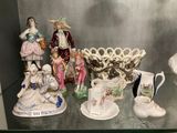 de nombreuses figurines exposées sur une étagère en verre dans une pièce