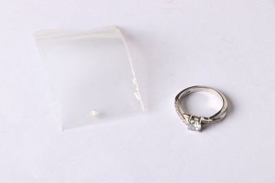 une bague en argent et un sac en plastique transparent posés sur une table