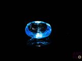 a close up of a blue diamond on a black surface