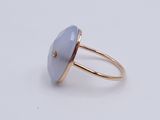 a close up of a ring on a white surface with a blue stone