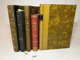 plusieurs vieux livres sont alignés sur une surface blanche