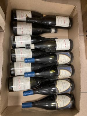 Les bouteilles de vin se trouvent dans un carton posé sur une table.